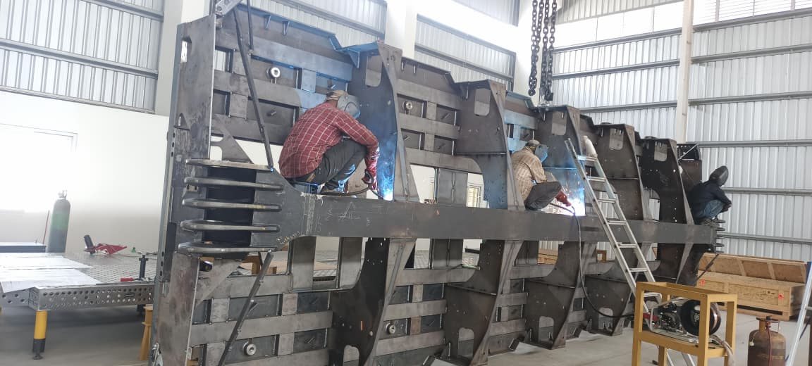 Welders fabricating a large heavy steel structure